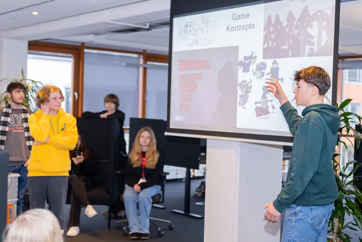 A student pitching his game concept drawings to the group