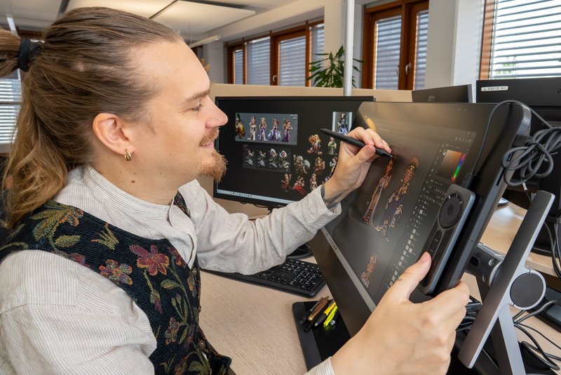 An InnoGames artist drawing on a pen display