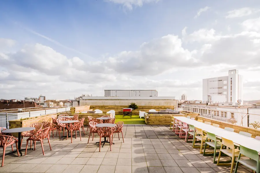 The roof terrace with tables and chairs in the sun