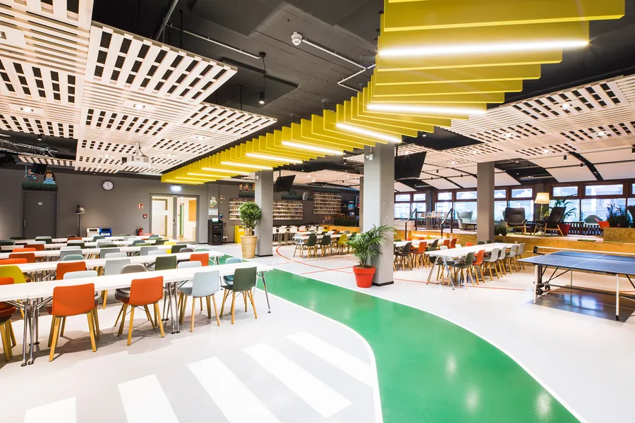 The Town Hall with long tables, colourful chairs and a yellow ceiling