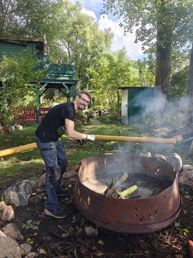 A colleague tending a fire pit