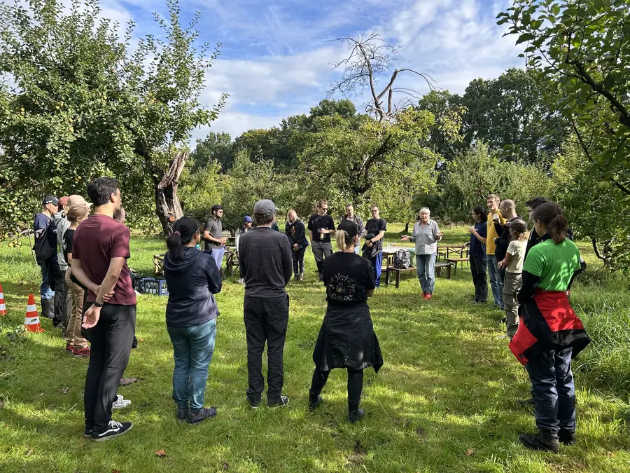 Colleagues gathered in a circle in the orchard
